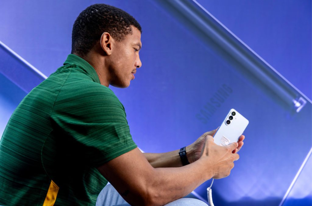 A Springbok in training kit holds a Galaxy phone at the Samsung launch